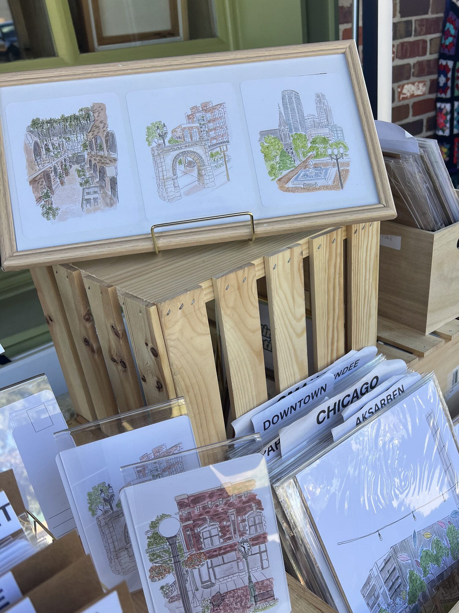 Nicole’s framed Omaha landmark prints and bins of cards at her pop-up booth