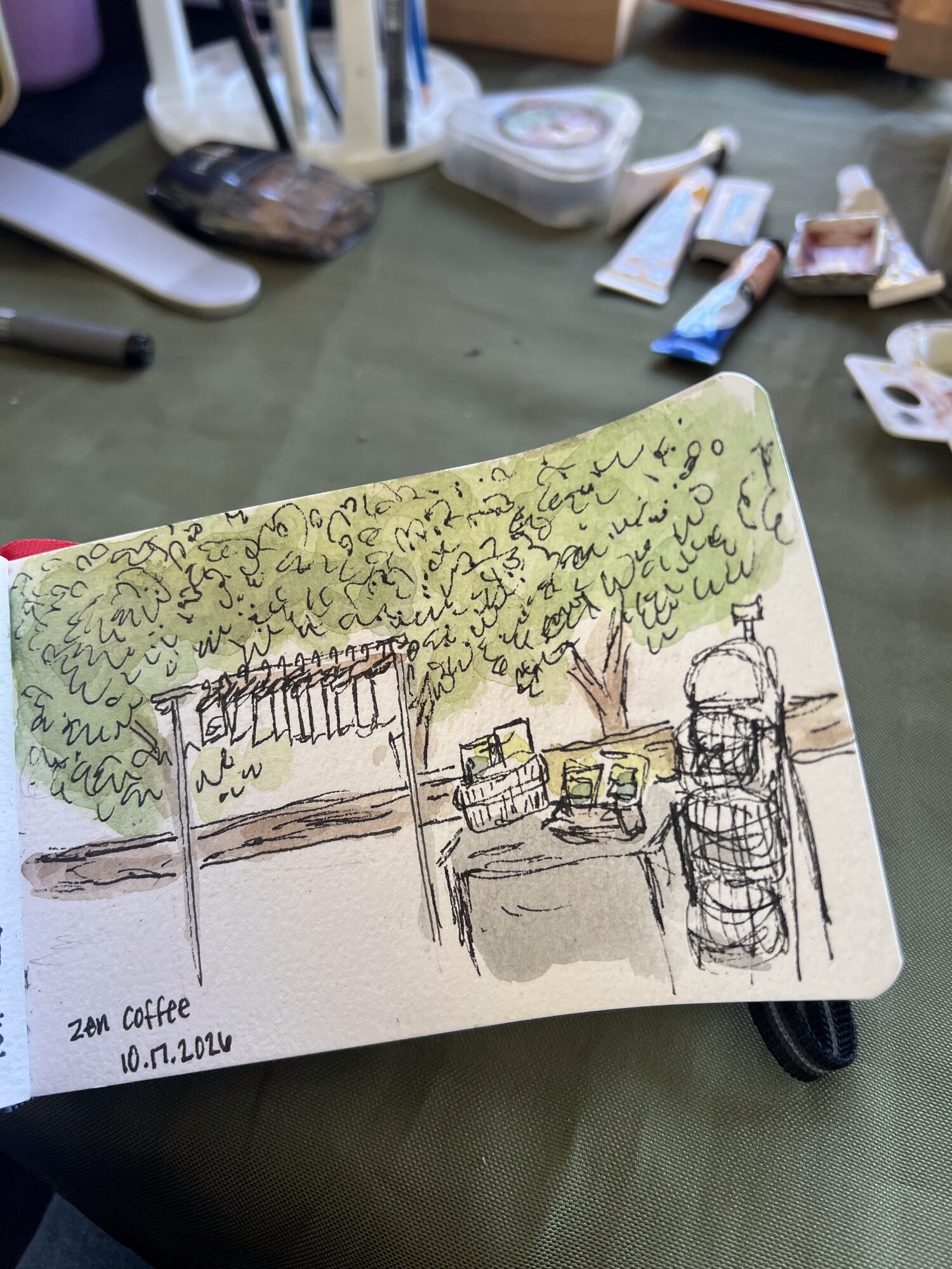 Nicole’s sketchbook page of the Zen Coffee porch under the trees, labeled Zen Coffee 10.17.2026