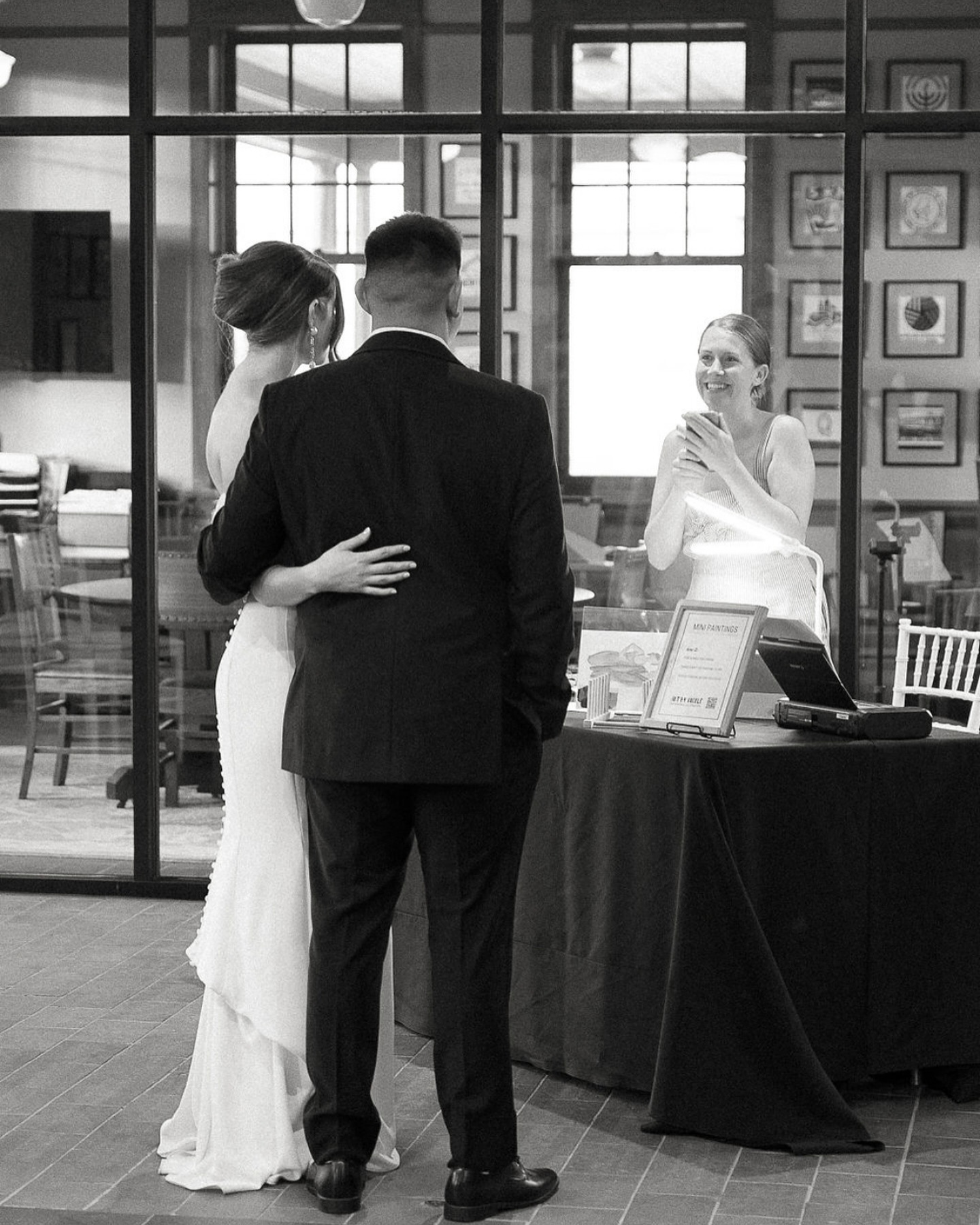 A bride and groom at Nicole’s live painting table