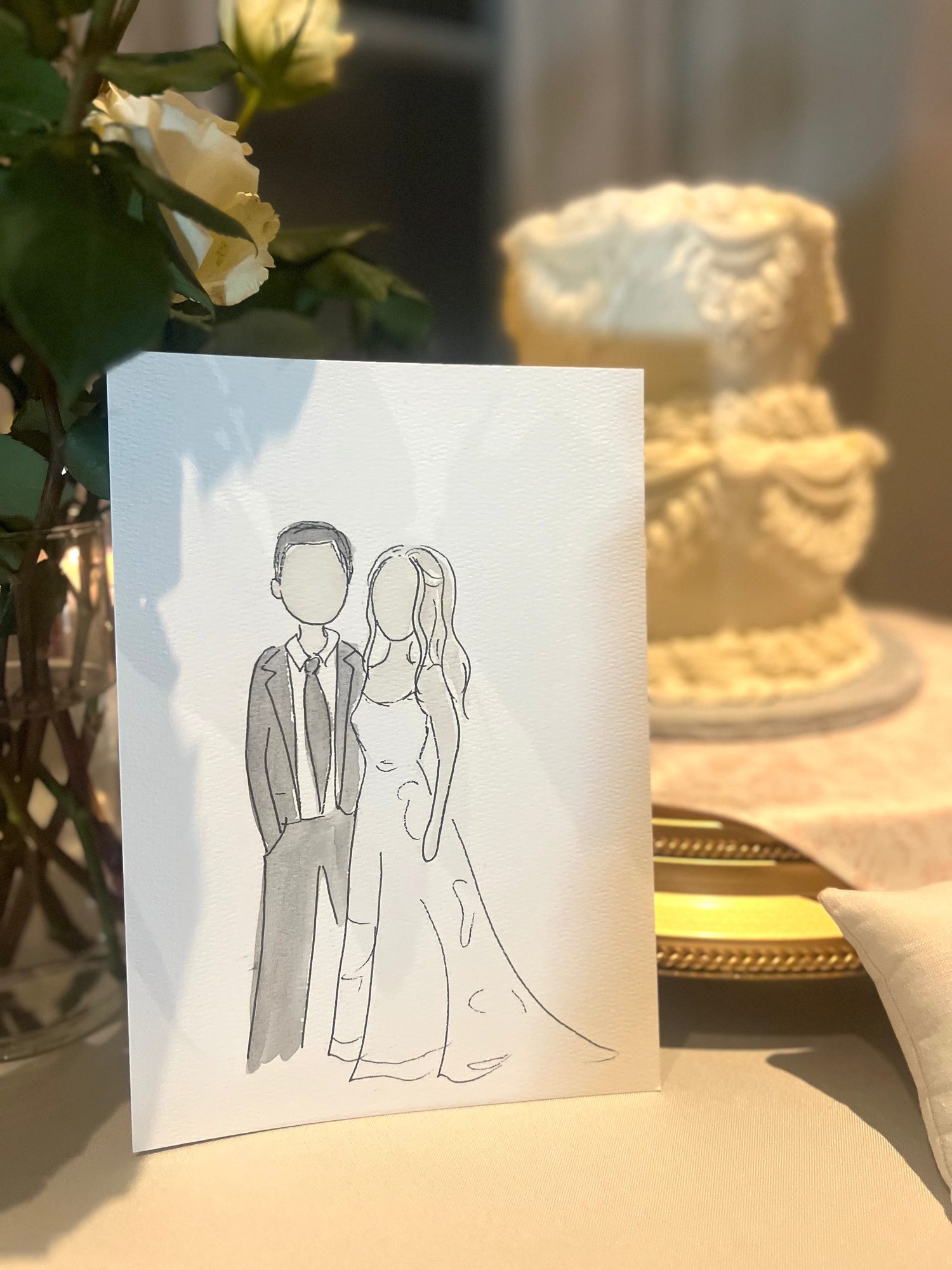 Mini portrait of a bride and groom propped beside the wedding cake