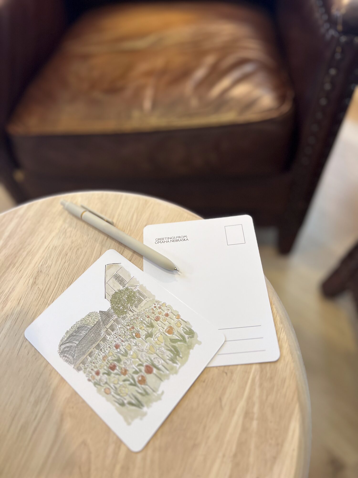 A watercolor garden postcard by Nicole on a café table