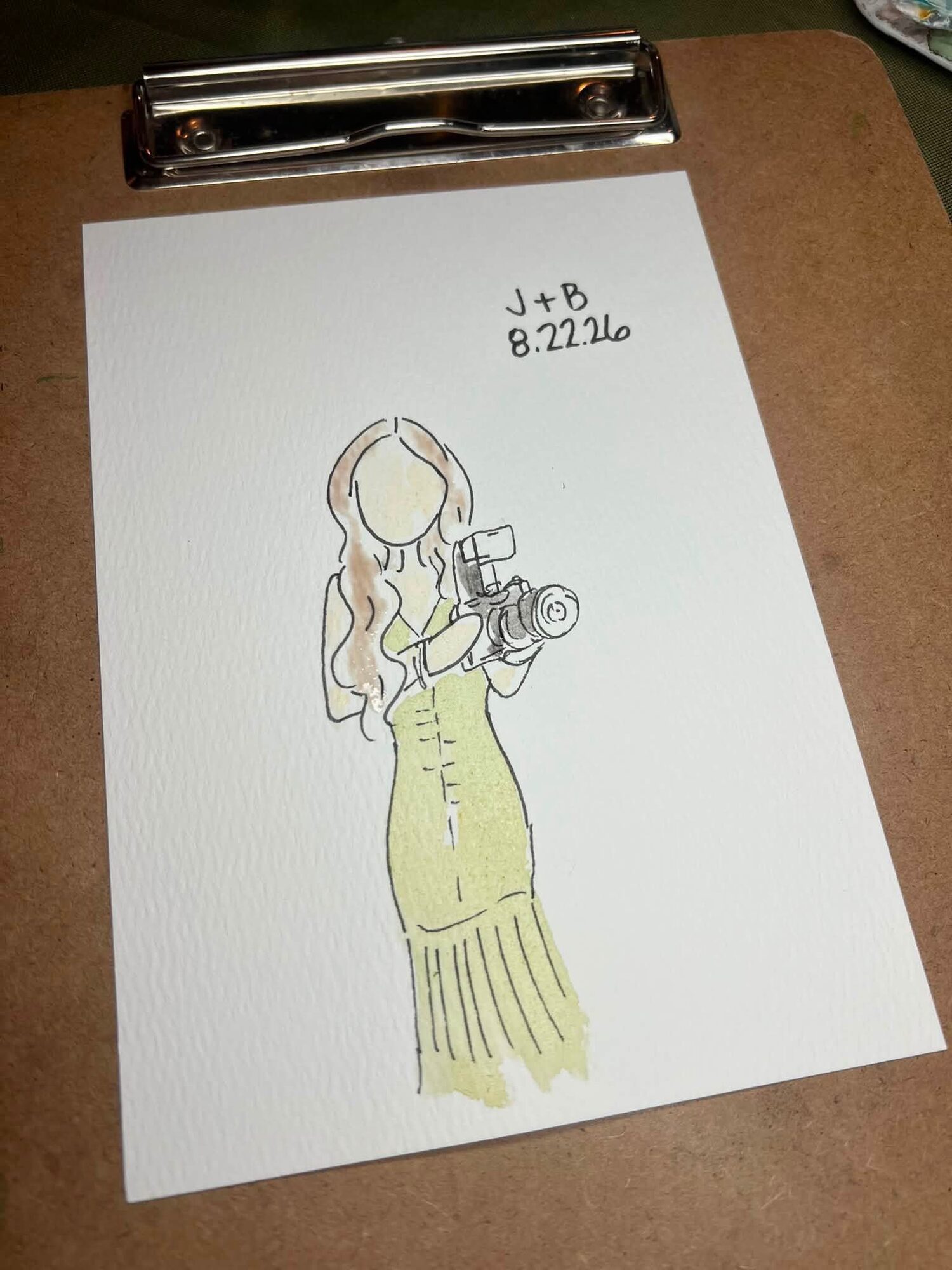 Mini portrait of a woman in a yellow dress holding a camera
